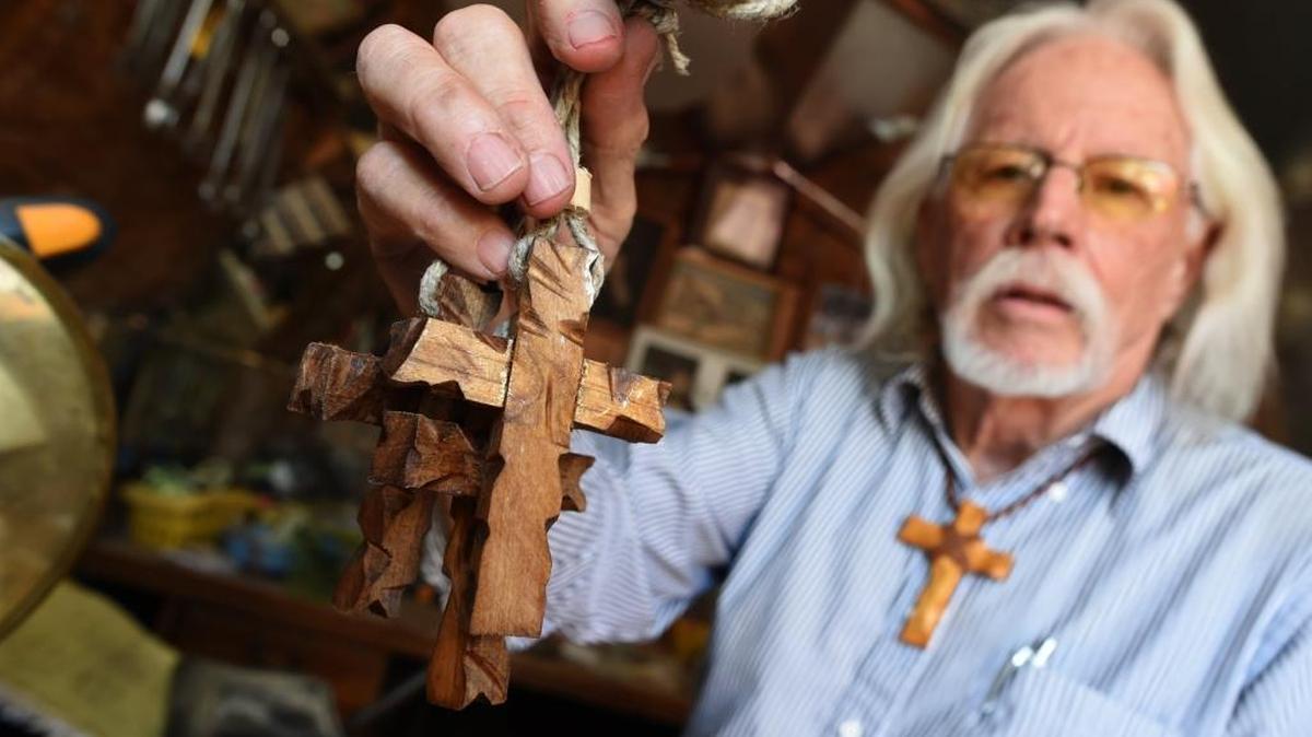 Michael Angelo makes small rustic crosses in the thousands to give out and spread the word of God.