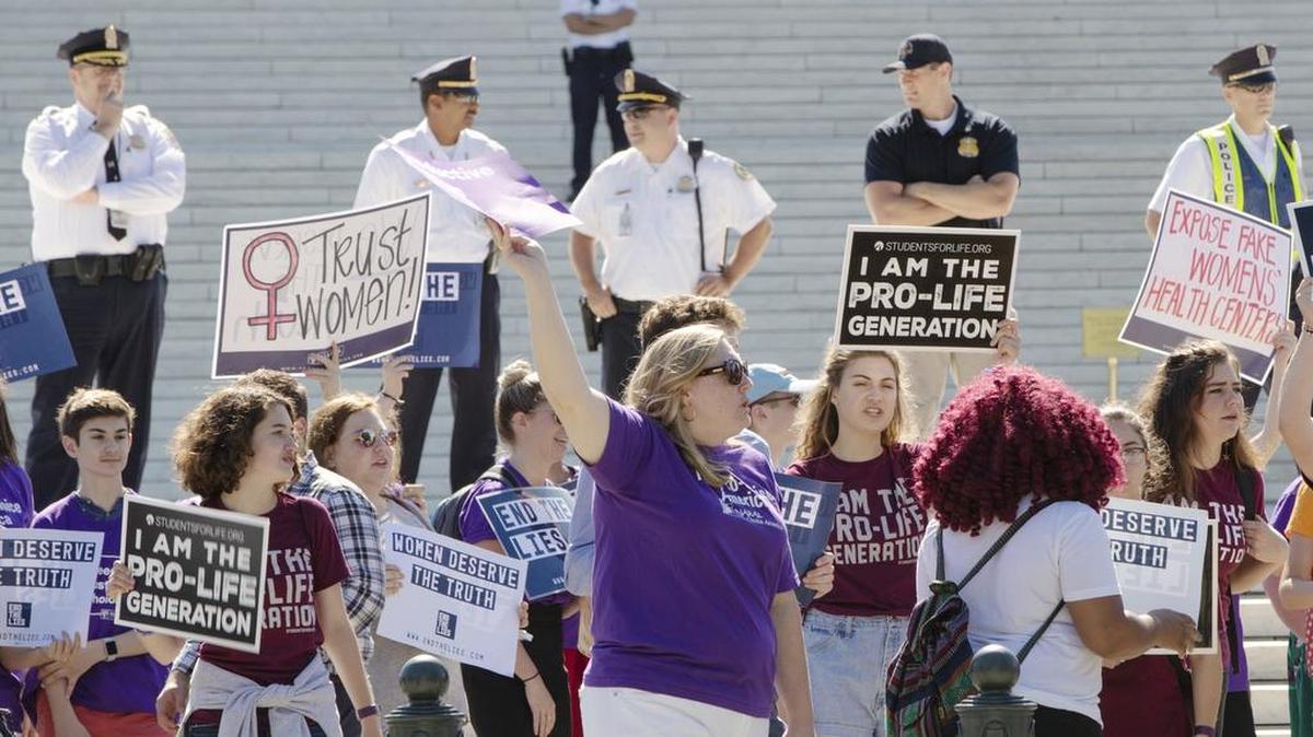 In this Monday, June 25, 2018 file photo, pro-choice and anti-abortion advocates hold signs as they demonstrate in front of the Supreme Court in Washington. Among those riveted by the drama of Brett Kavanaugh’s Supreme Court nomination are the rival sides in America’s abortion debate, each convinced that the nationwide right to abortion is at stake.