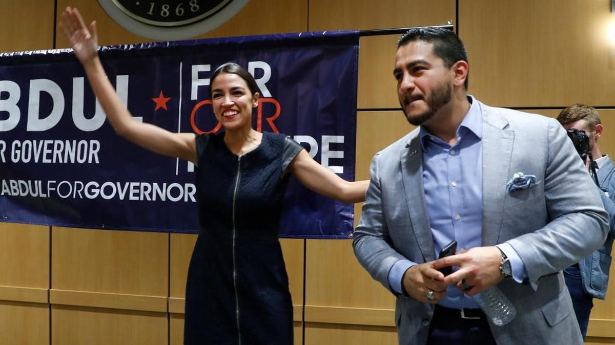 Alexandria Ocasio-Cortez, a Democratic congressional candidate from New York, waves with Michigan Democratic gubernatorial candidate Abdul El-Sayed during a campaign event in Detroit, Saturday, July 28, 2018. (AP Photo/Paul Sancya)