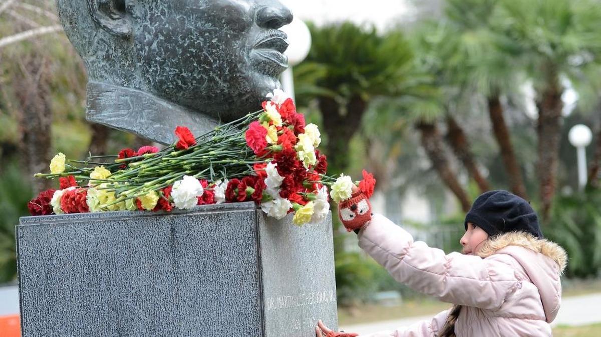 Juliana De La Cerda places a carnation on the MLK statue at Fresno County Courthouse Park in downtown Fresno.