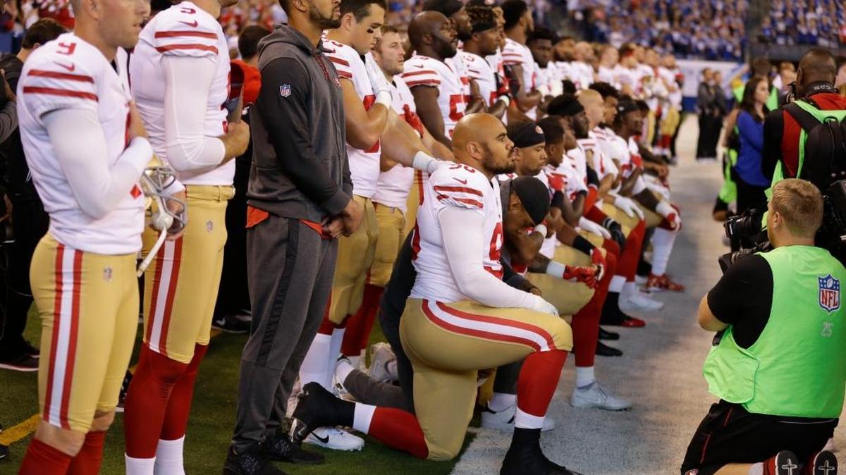 Members of the San Francisco 49ers kneel during the playing of the national anthem before an NFL football game against the Indianapolis Colts Oct. 8 in Indianapolis.