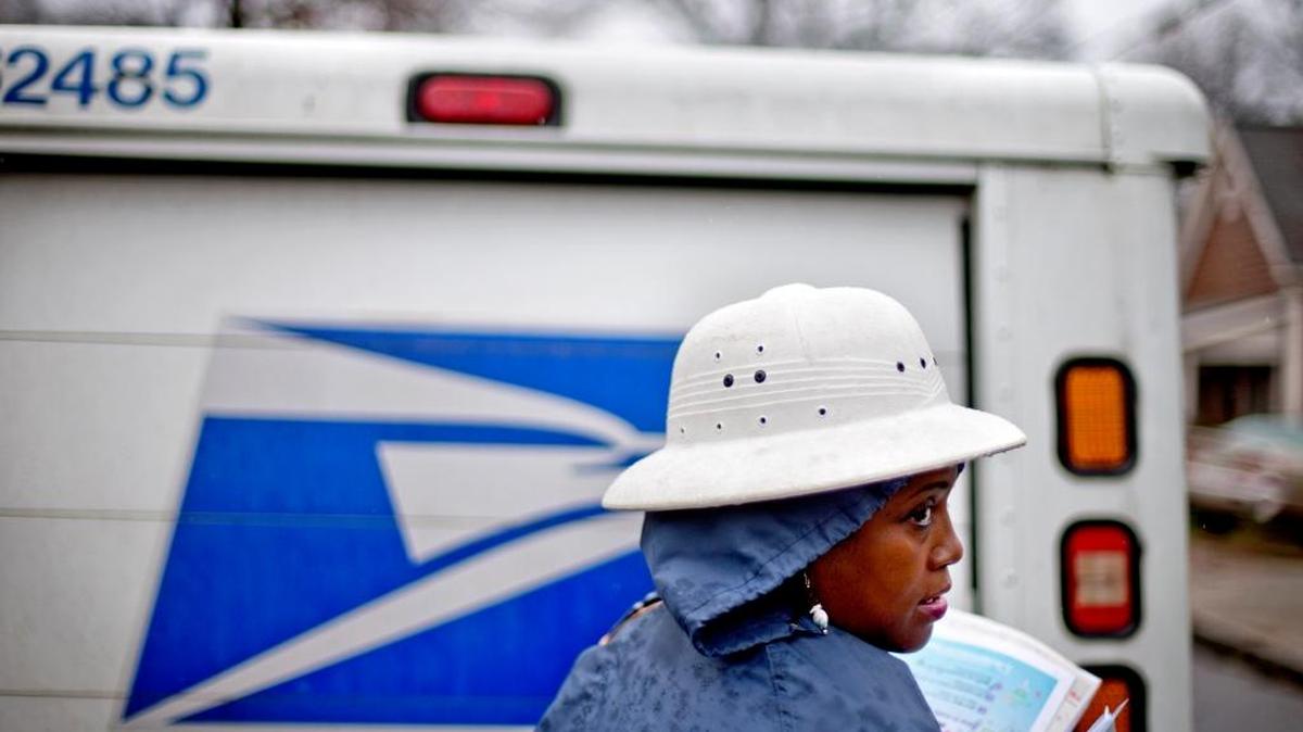 U.S. Postal Service letter carrier Jamesa Euler delivers mail in the rain in Atlanta.