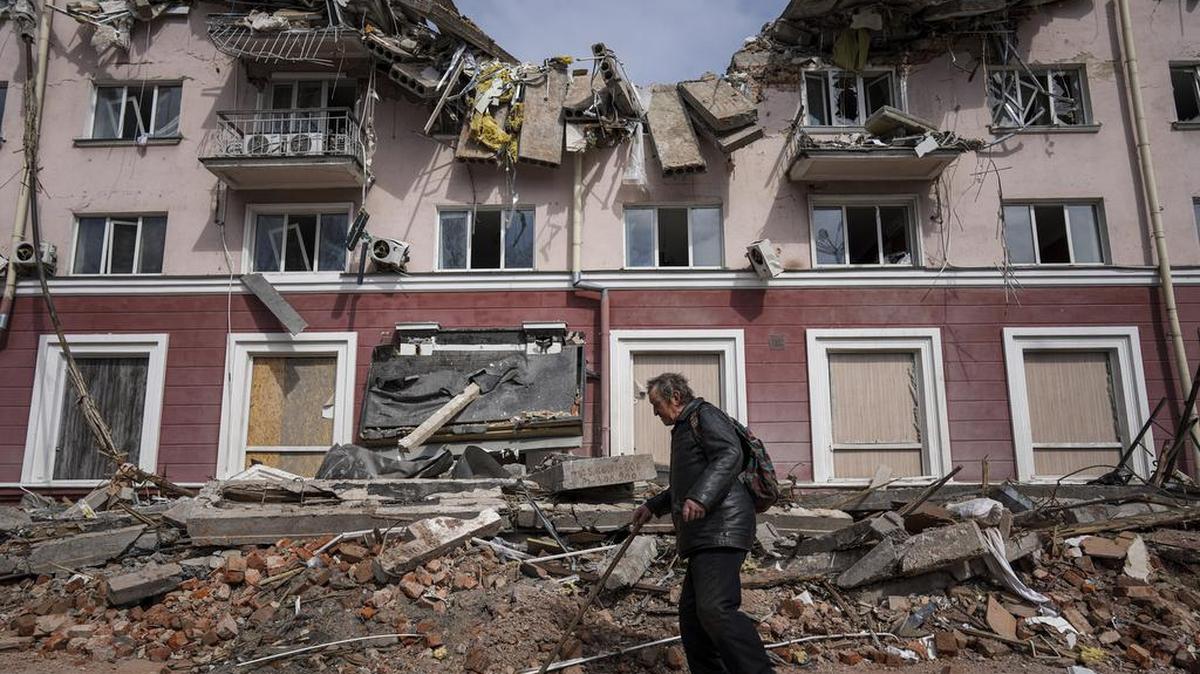 A man walks past a building damaged by shelling in Chernihiv, Ukraine, Thursday, April 7, 2022.
