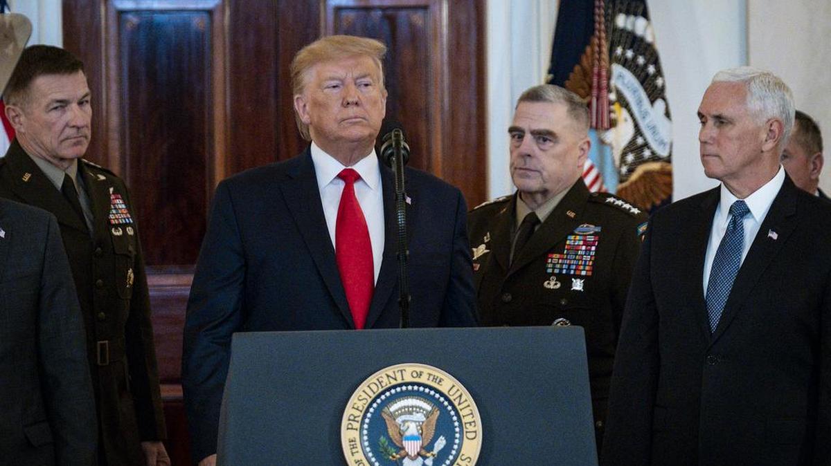 Surrounded by Secretary of Defense Mark Esper, Vice President Mike Pence and Secretary of State Mike Pompeo, as well as the Joint Chiefs of Staff, President Donald Trump walks to the podium to deliver a statement in the Grand Foyer of the White House, in response to Iran firing more than a dozen ballistic missiles at two Iraqi military bases housing U.S. troops, on Wednesday, Jan. 8, 2020 in Washington, D.C.