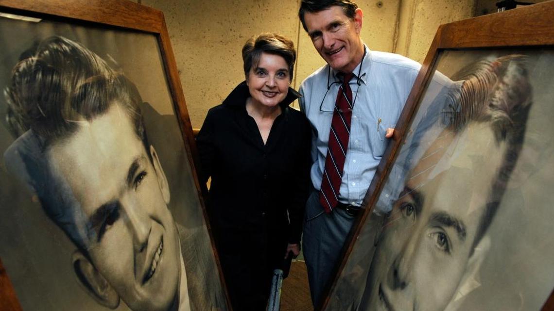 Curator Jill Moffatt, left, and retiring Fresno State Dean of Library Services Peter McDonald, right, pose with two large posters featuring Olympic discus medal winner Sim Inness, left, and Olympic decathalon champion Bob Mathias, right, during a 2013 exhibition at the Henry Madden Library.