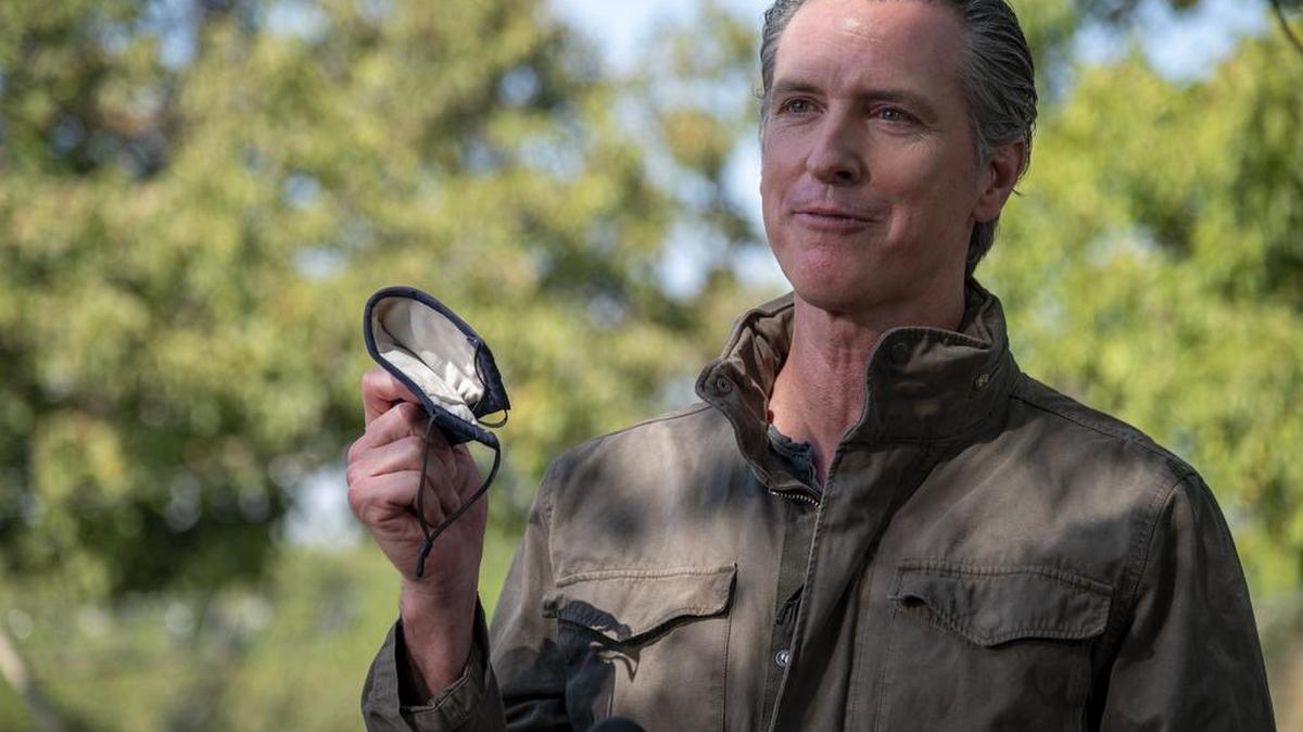 FILE - In this Oct. 7 photo, Gov. Gavin Newsom talks about the importance of wearing a face mask during a news conference at Sierra Orchards walnut farm in Winters.