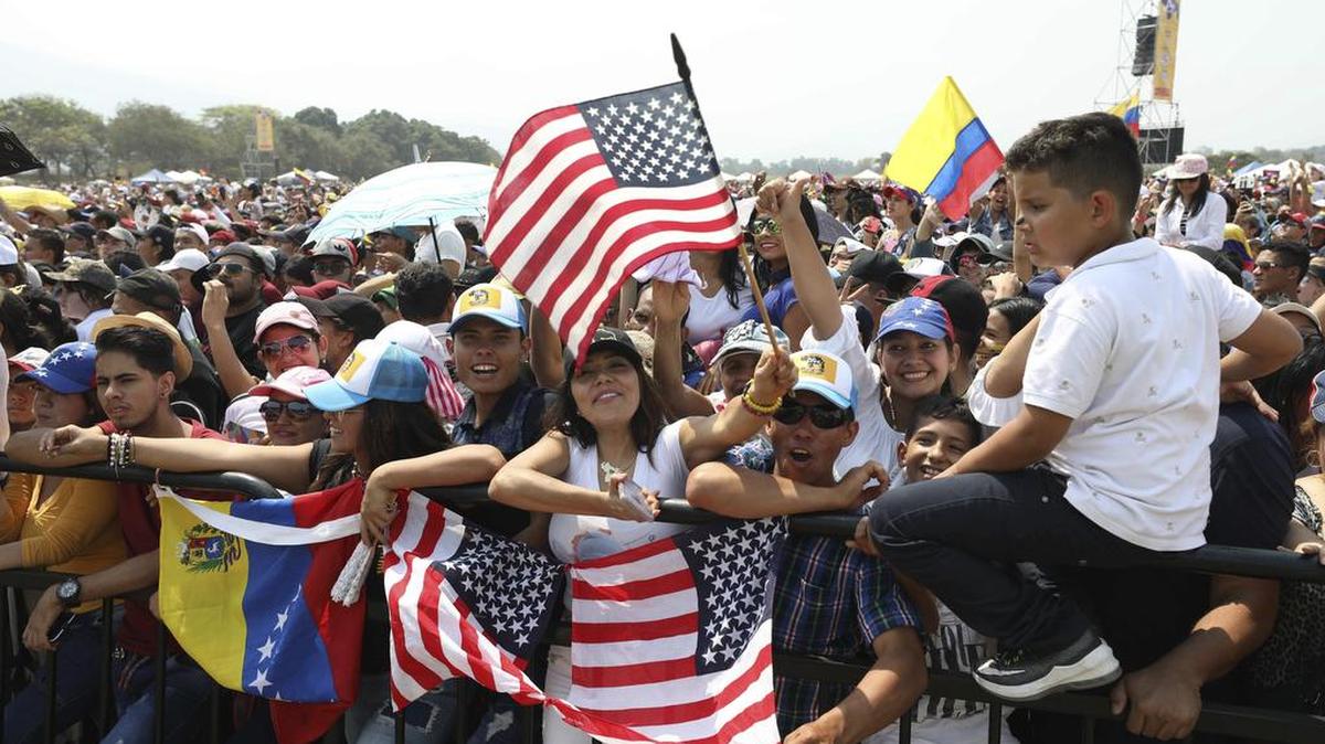 Fans wave Venezuelan and United States flags during the Venezuela Aid Live concert on the Colombian side of the Tienditas International Bridge near Cucuta, Colombia, on the border with Venezuela Friday, Feb. 22, 2019. Venezuela's power struggle was set to become a battle of the bands Friday when musicians demanding President Nicolas Maduro allow in humanitarian aid and those supporting his refusal sang in rival concerts held at both sides of a border bridge where tons of donated food and medicine were stored.