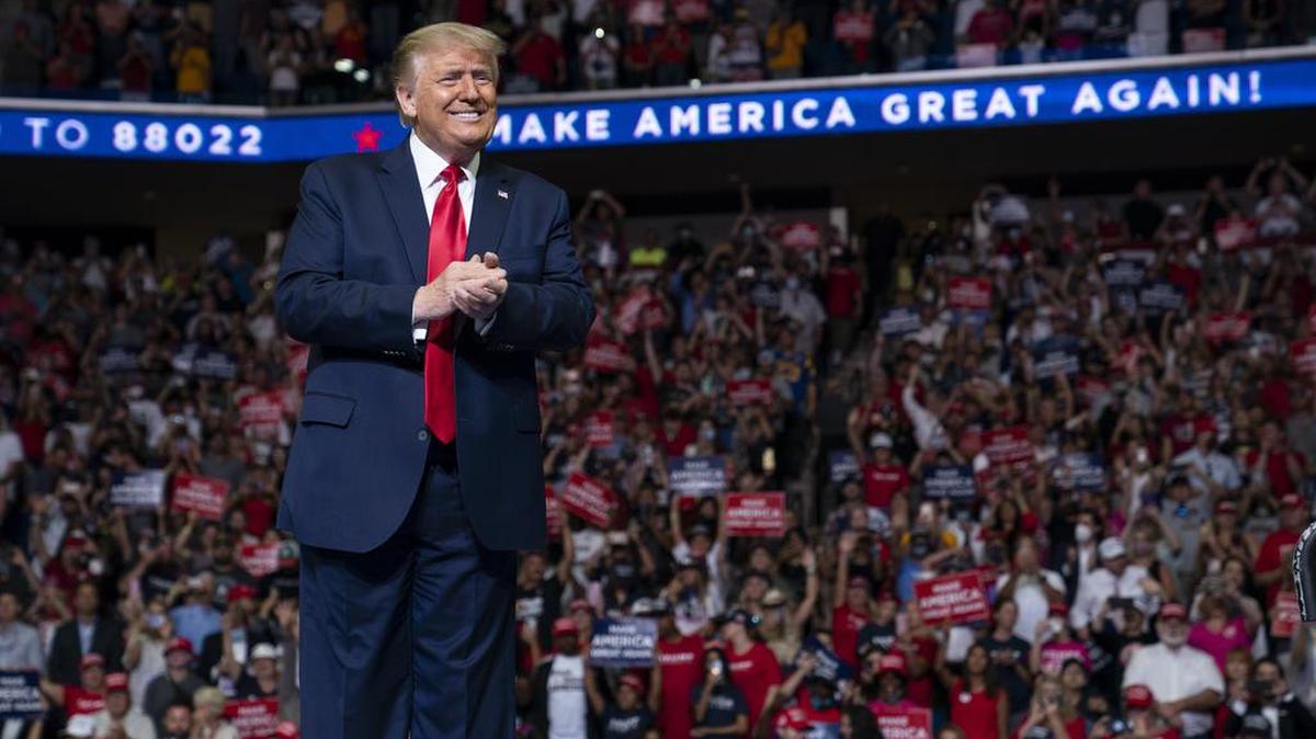 FIL E- In this June 20, 2020, file photo President Donald Trump arrives on stage to speak at a campaign rally at the BOK Center in Tulsa, Okla. After months of insisting that the Republican National Convention go off as scheduled despite the coronavirus pandemic, Trump is slowly coming to accept that the event will not be the four-night informercial for his re-election that he had anticipated. (AP Photo/Evan Vucci, File)