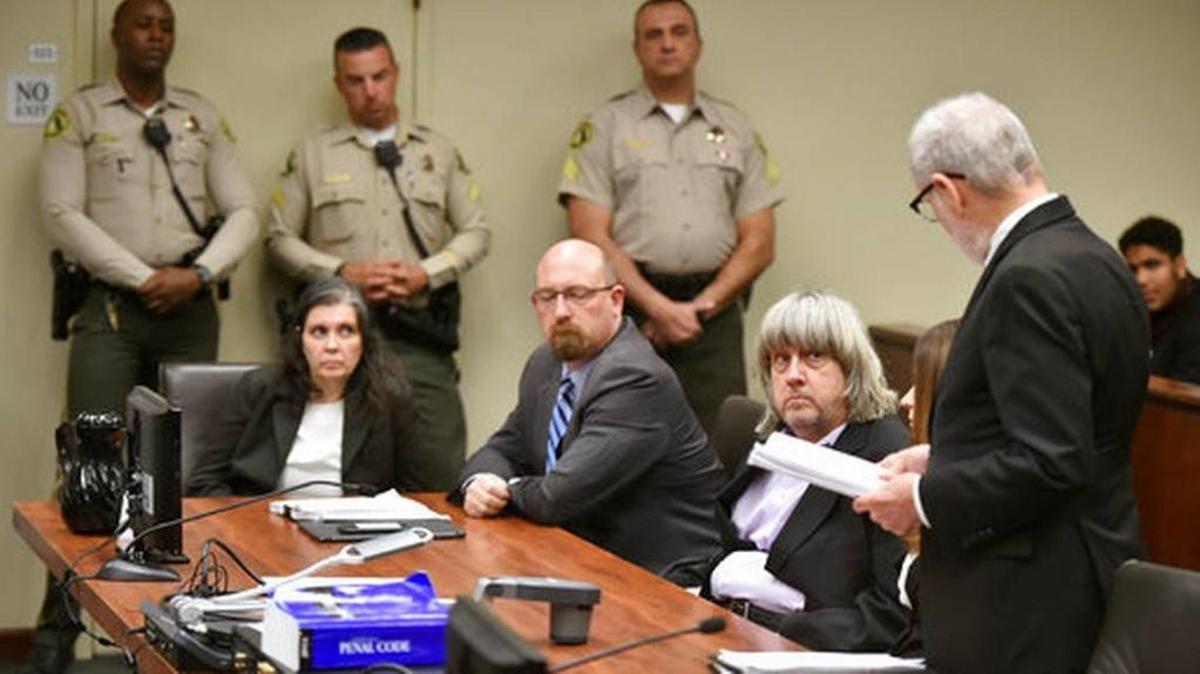 Louise Anna Turpin, far left, with attorney Jeff Moore, second from left, and her husband David Allen Turpin, listen to attorney, David Macher, as they appear in court for their arraignment in Riverside, Jan. 18. The parents of 13 siblings, who were allegedly held in captivity in their family's Southern California home,were charged Thursday with committing years of torture and abuse that left their children malnourished, undersized and with cognitive impairments.