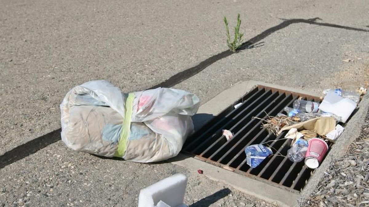 Garbage piled up on a drain cover on Highway 168.
