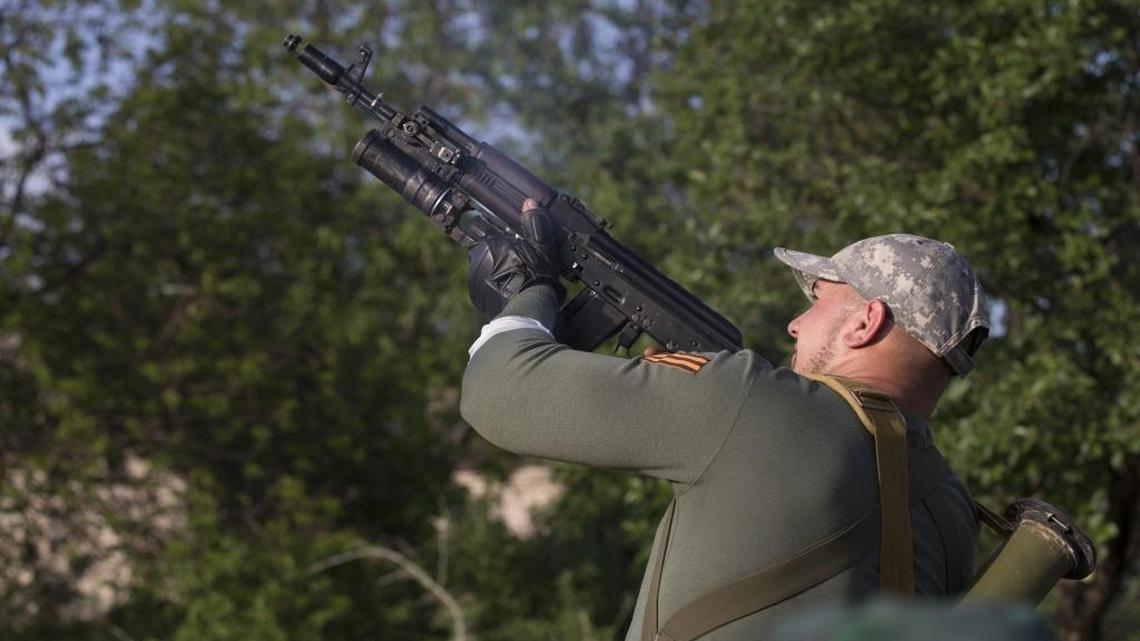 A pro-Russian man shoots grenade launcher against Ukrainian government troops at a checkpoint outside Slovyansk, eastern Ukraine.