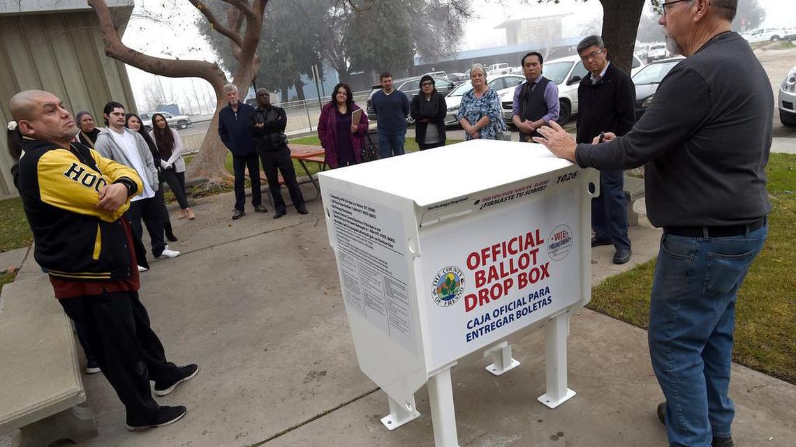 Russell Chappell, Fresno County elections outreach coordinator, right, explains to new elections employees the use of a new secure ballot drop box, one of 43 that will be used throughout the county. It was one of the changes for the March 2020 presidential primary election for the county. Ballot boxes are in place now for the November election.