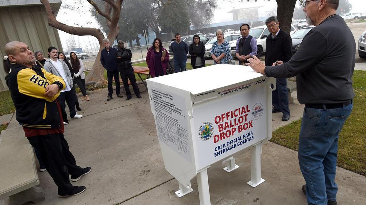 Russell Chappell, Fresno County elections outreach coordinator, right, explains to new elections employees the use of a new secure ballot drop box, one of 43 that will be used throughout the county. It was one of the changes for the March 2020 presidential primary election for the county.