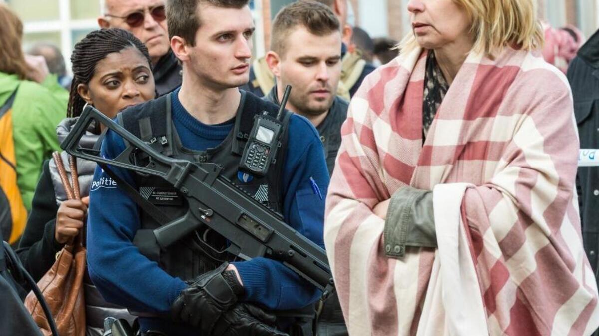 A police officer stands guard as people are evacuated after explosions rocked the airport in Brussels on Tuesday, March 22, 2016.