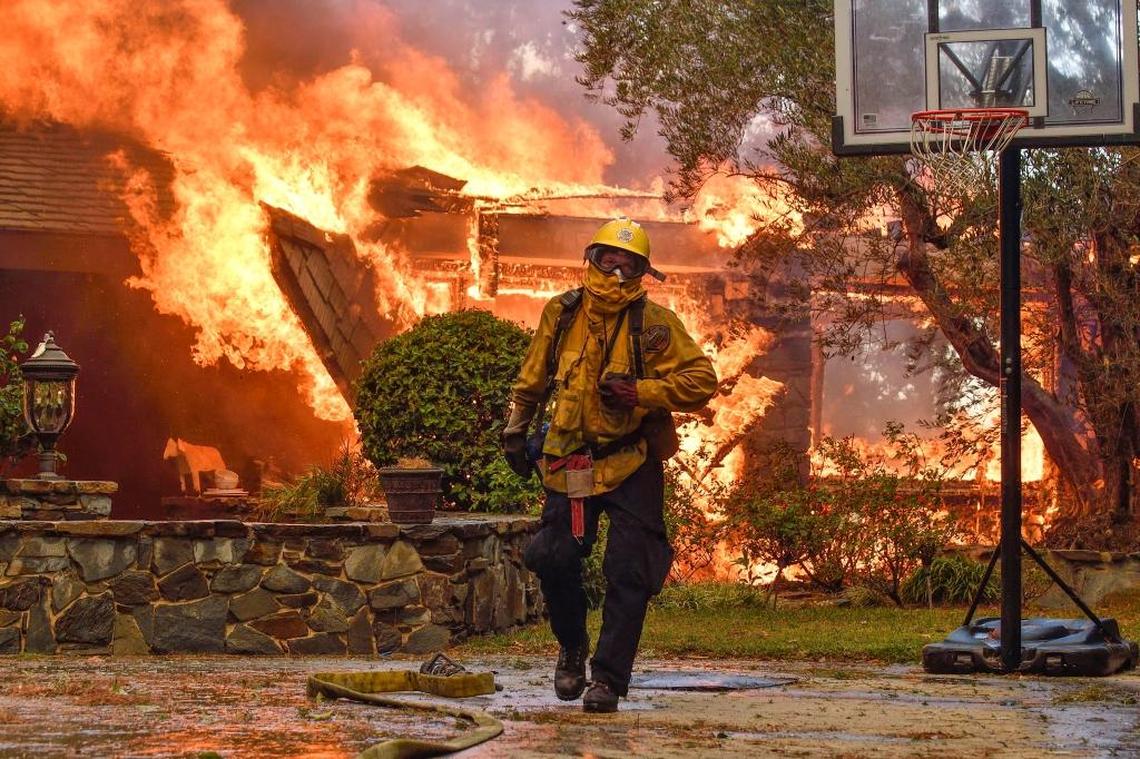 Firefighters work to extinguish a fire at a home as they battle a wildfire in Anaheim Hills, Calif., Oct. 9, 2017.