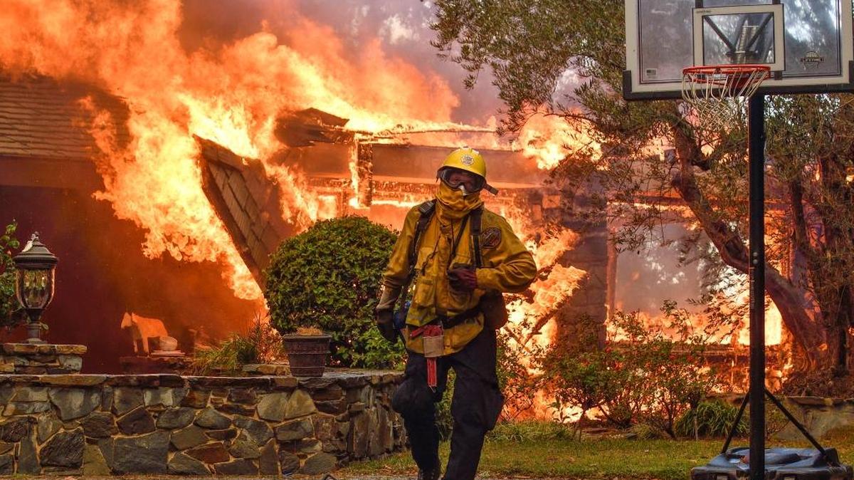 Firefighters work to extinguish a fire at a home as they battle a wildfire in Anaheim Hills, Calif., Oct. 9, 2017.