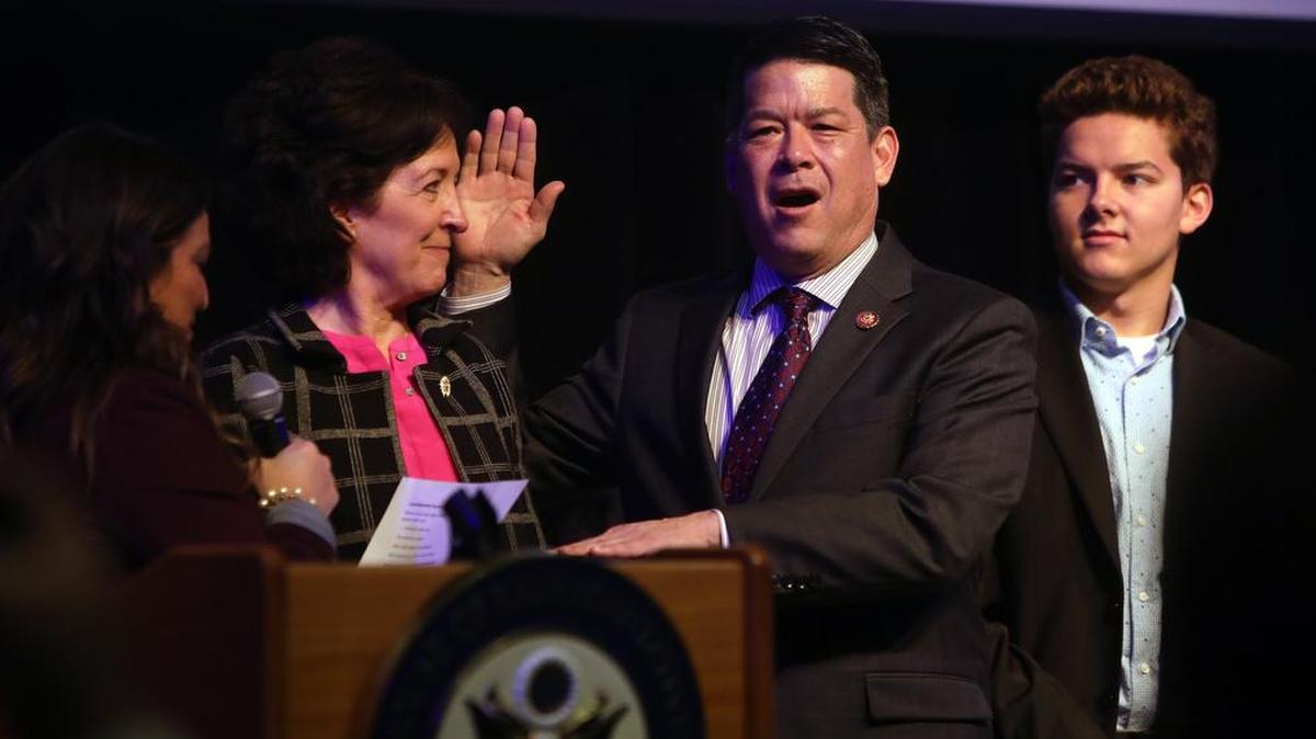 Democratic Congressman TJ Cox is sworn in by Fresno City Councilmember Esmeralda Soria while his wife, Kathleen Murphy, looks on.