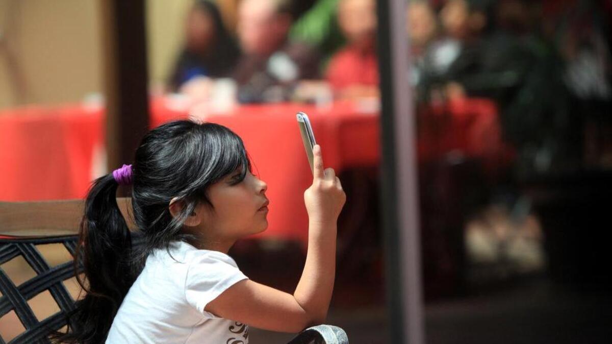 Luz Liliana Hernández uses a cell phone to record a news conference in this file photo
