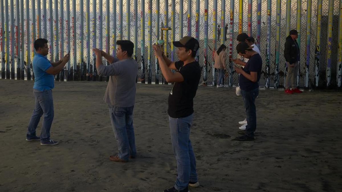 People record with their phones in front of the border wall Thursday, Jan. 10, 2019, along the beach in Tijuana, Mexico. Taking the shutdown fight to the Mexican border, U.S. President Donald Trump edged closer Thursday to declaring a national emergency in an extraordinary end run around Congress to fund his long-promised border wall.
