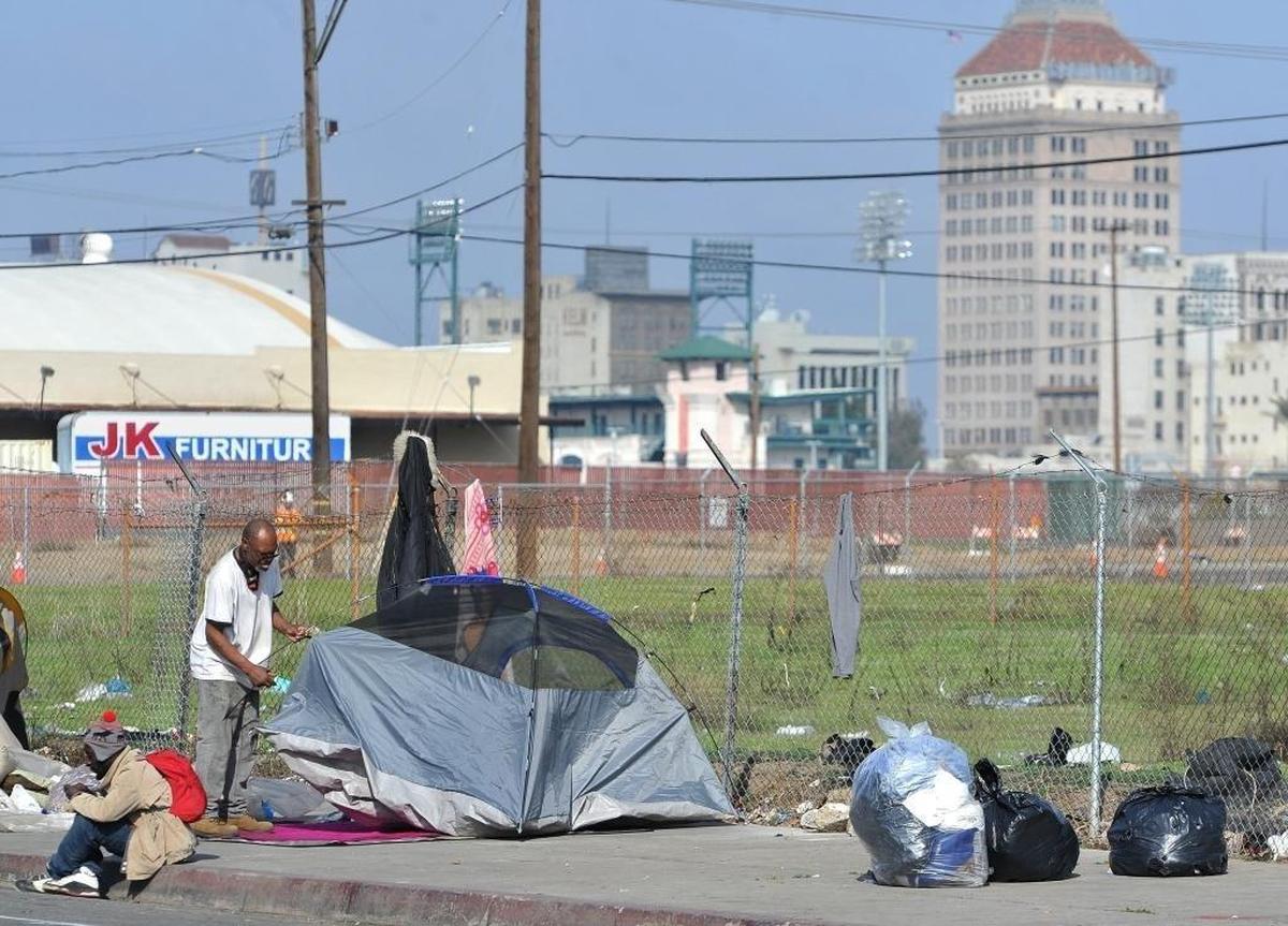 A homeless man sets up his tent near downtown Fresno. Both Fresno County and the city of Fresno introduced ordinances in late July and early August 2024 banning camping on streets, sidewalks parks and other public property. Both the city and county laws include misdemeanor penalties such as fines or jail time for those who refuse to move when asked by police officers or sheriff’s deputies.