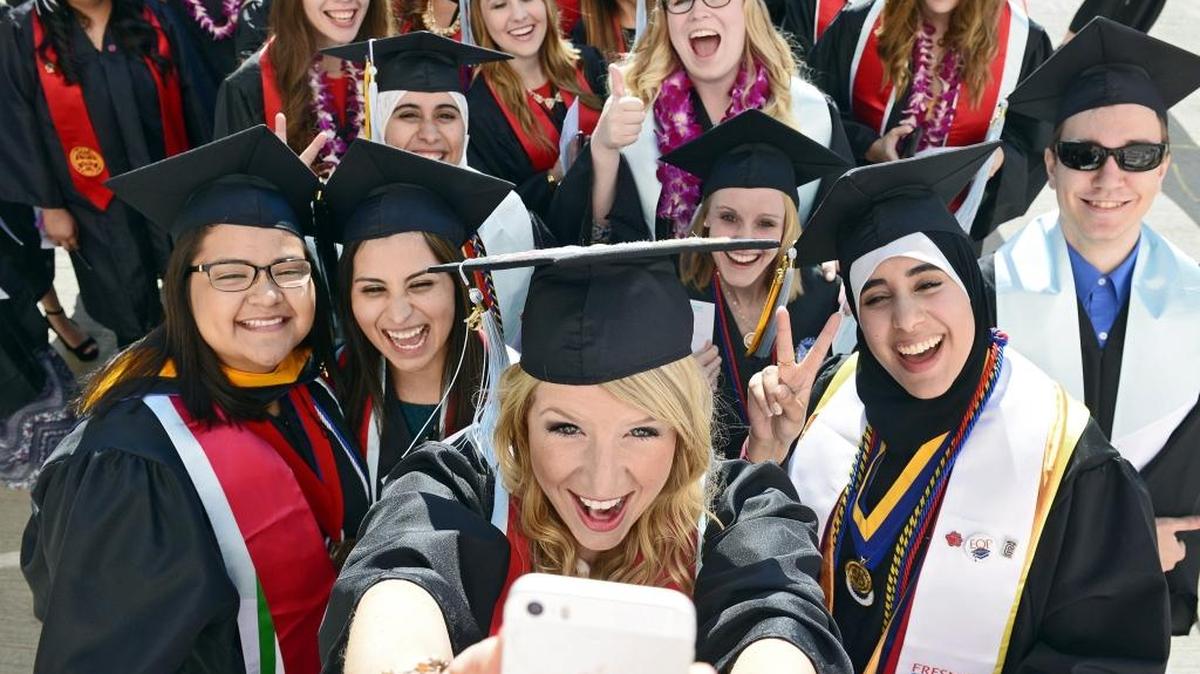 Fresno State graduate Ludie Olenchalk, center, takes a group selfie photo with Kreman School of Education and Human Development classmates before entering the Save Mart Center for the university’s 104th commencement May 16, 2015. A recent study says that CSU schools must graduate 2 million students between now and 2030 to meet California’s economic demands.