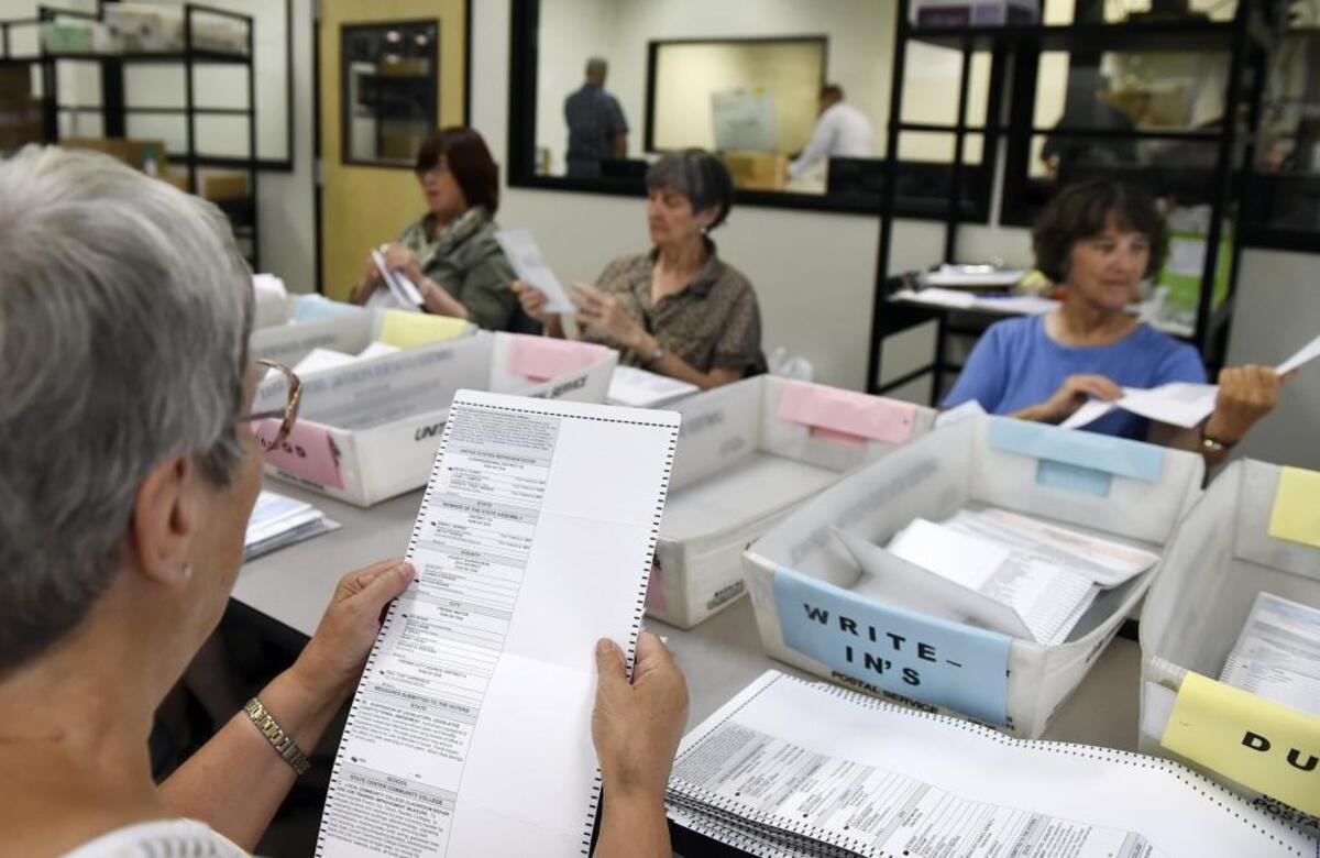 Fresno’ s League of Women Voters check vote-by-mail ballots, as elections workers begin processing vote-by-mail and provisional ballots at Fresno County's Elections Warehouse during the June elections.