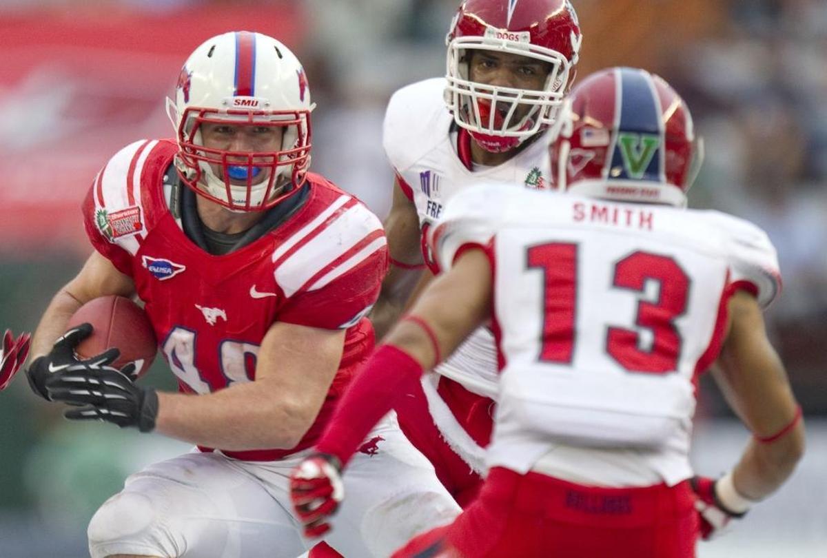 SMU running back Zach Line splits Fresno State defensive back Derron Smith (13) and linebacker Tristan Okpalaugo on a run in the 2012 Hawaii Bowl.