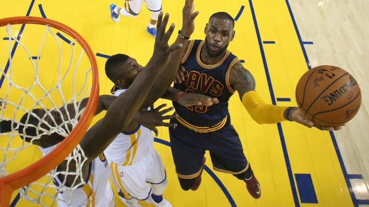 Cleveland Cavaliers forward LeBron James, right, shoots against the Golden State Warriors during the second half of Game 1 of the NBA Finals Thursday in Oakland. The Warriors won 104-89.