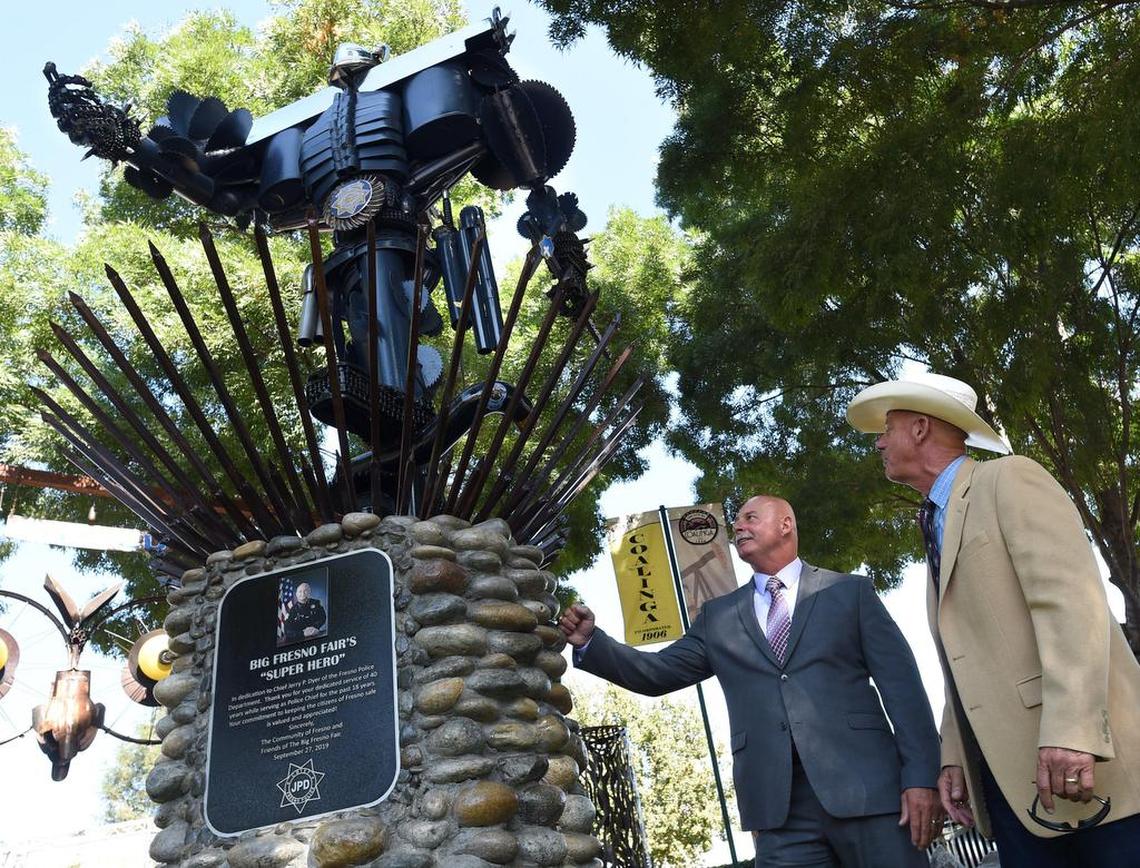 Fresno Police Chief Jerry Dyer, with Big Fresno Fair CEO John Alkire, right, admire the art piece in Dyer’s honor after its unveiling Friday morning, Sept. 27, 2019, at the fairground’s Iron Mountain display at the Pavilion Stage. Symbolic pieces in the artwork pay tribute to Dyer and the police force, such as his badge and SWAT and motorcycle units.