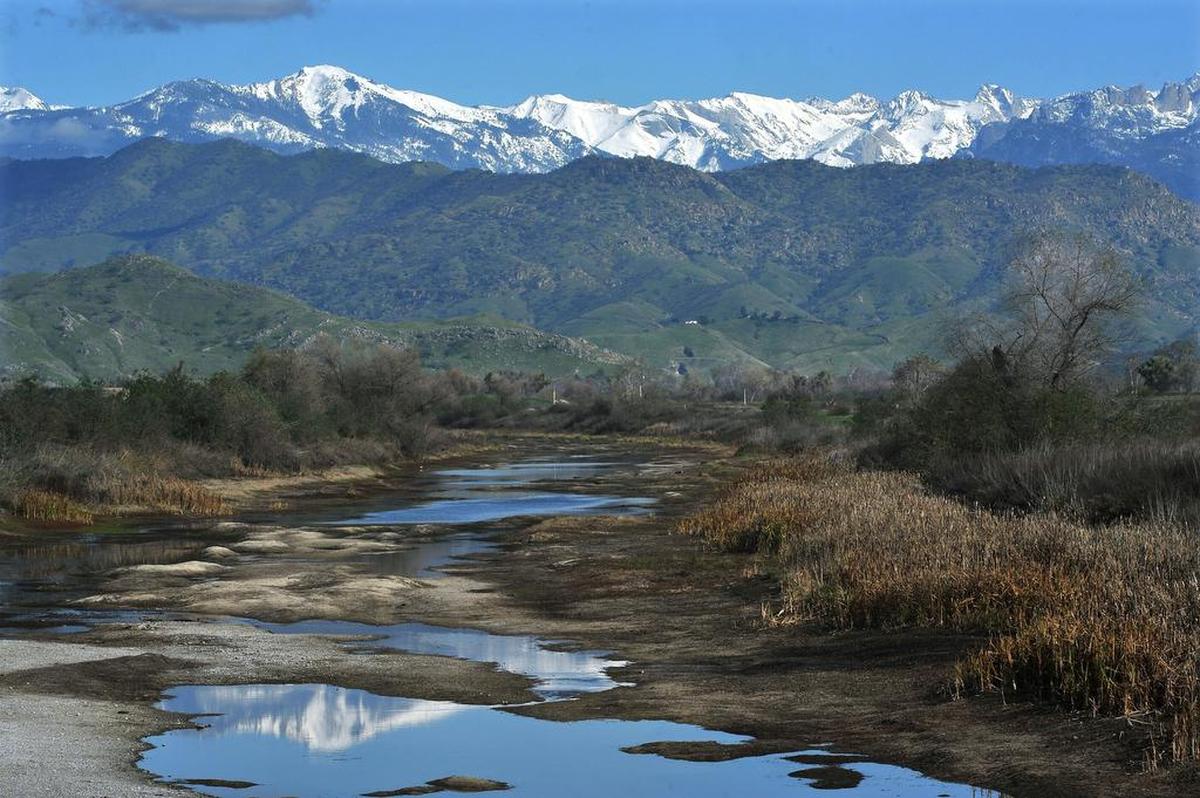 The snow-covered Kaweah Range of the Sierra Nevada looms over the foothills and Kaweah River near Woodlake on Tuesday.