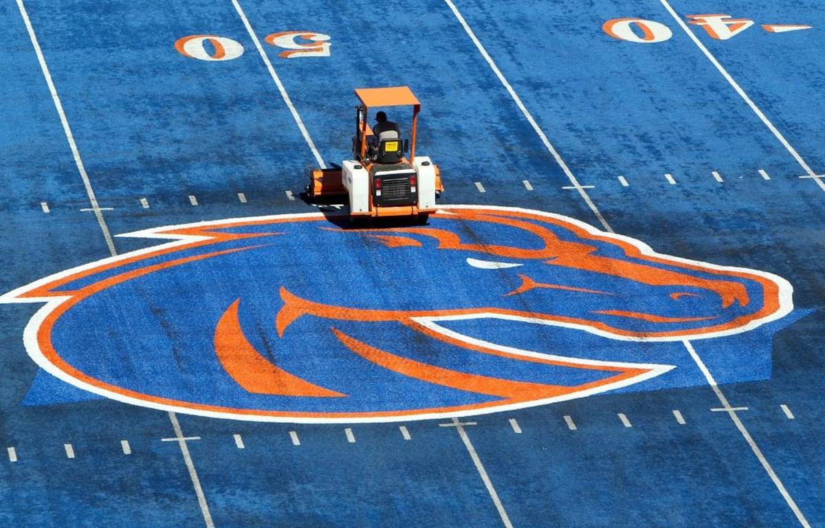 A crew member works on the Boise State logo at midfield of Albertsons Stadium, site of Saturday’s Mountain West Conference championship game between Fresno State and Boise State.