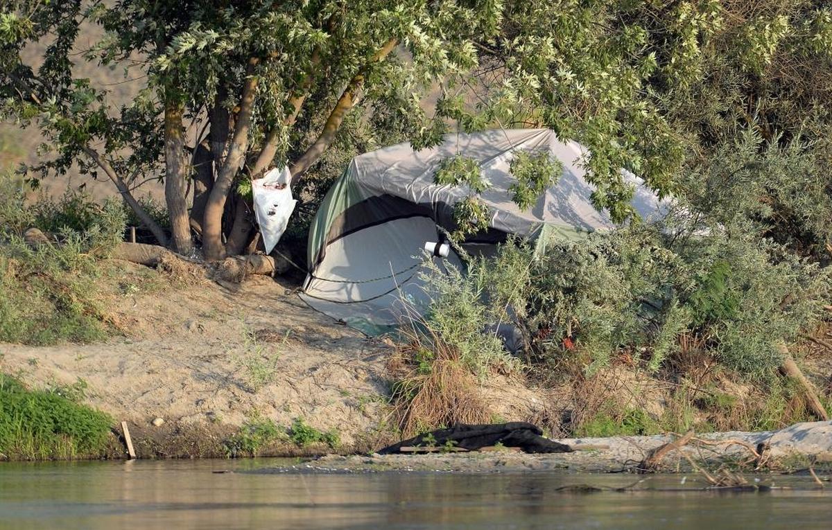 A homeless encampment sits next to the water along the San Joaquin River just north of Fresno in August 2017.