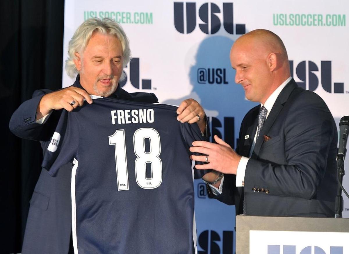 In this file photo, United Soccer League president Jake Edwards, right, receives a 2018 jersey from Fresno FC owner Ray Beshoff during a news conference officially announcing the expansion franchise at Chukchansi Park.