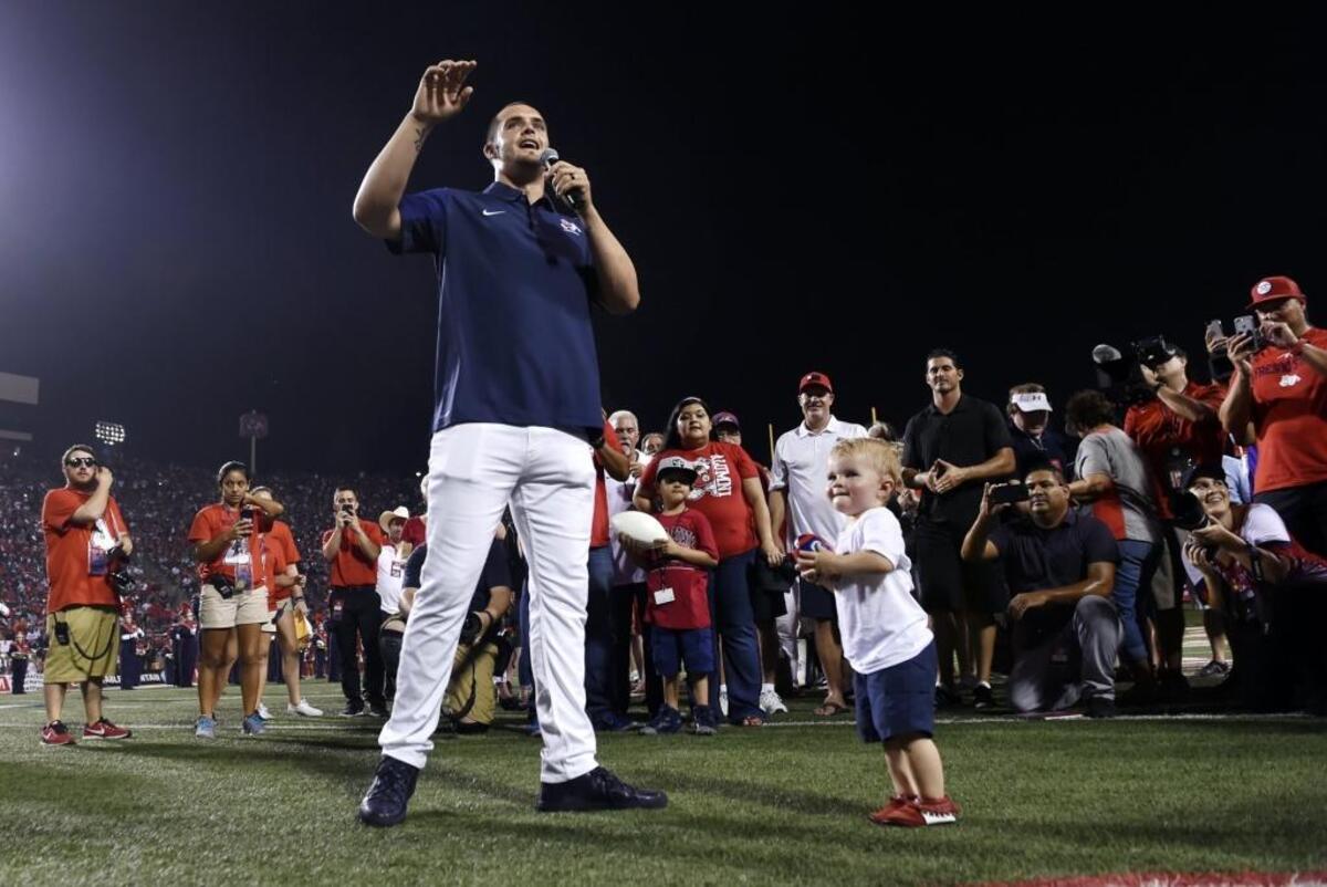 Derek Carr, with youngest son Deter at his feet, addresses the crowd during Saturday night’s halftime ceremony at Bulldog Stadium commemorating his jersey number retirement. In the background, Derek’s older brother David Carr stands next to Kevin Sweeney.