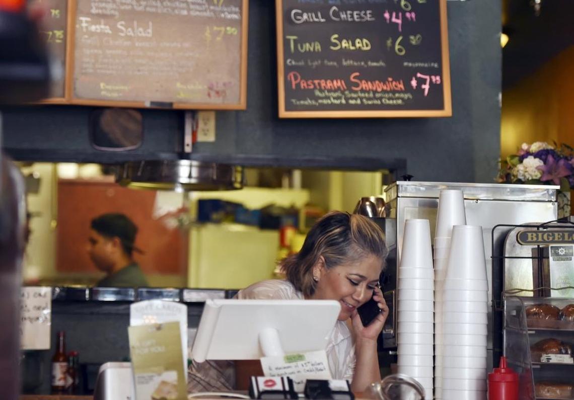 Parsley Garden Cafe co-owner Blanca Partida takes a phone order while 21-year-old son Alex works in the kitchen on a recent Monday. Blanca and Alex have been nearly alone in the downtown Fresno restaurant since February when Carlos Partida, Blanca’s husband, suffered a stress-related heart attack.