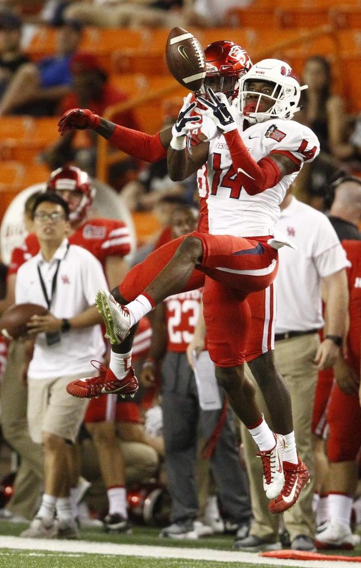 Fresno State cornerback Jaron Bryant (14) comes up with an interception on a pass intended for Houston wide receiver Steven Dunbar during the fourth quarter of the Bulldogs’ 33-27 victory in Honolulu on Dec. 24, 2017. Bryant returned the pick 44 yards for the clinching touchdown.