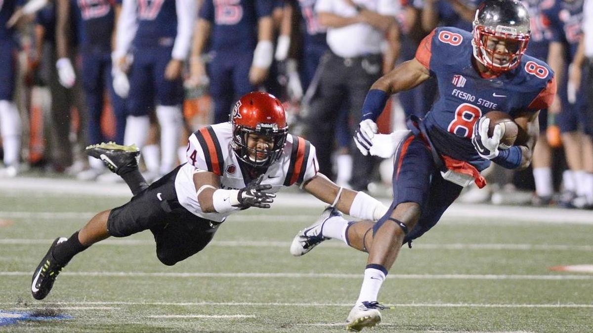 
Fresno State’s Da’Mari Scott dashes past a diving Billy Vaughn Jr. of San Diego State after making a catch for a long gain during the 2014 season. Scott finished the year with eight catches for 214 yards and one touchdown. Family and other issues led him to quit the team, then changed his mind and was granted a second chance by the coaching staff and teammates.
