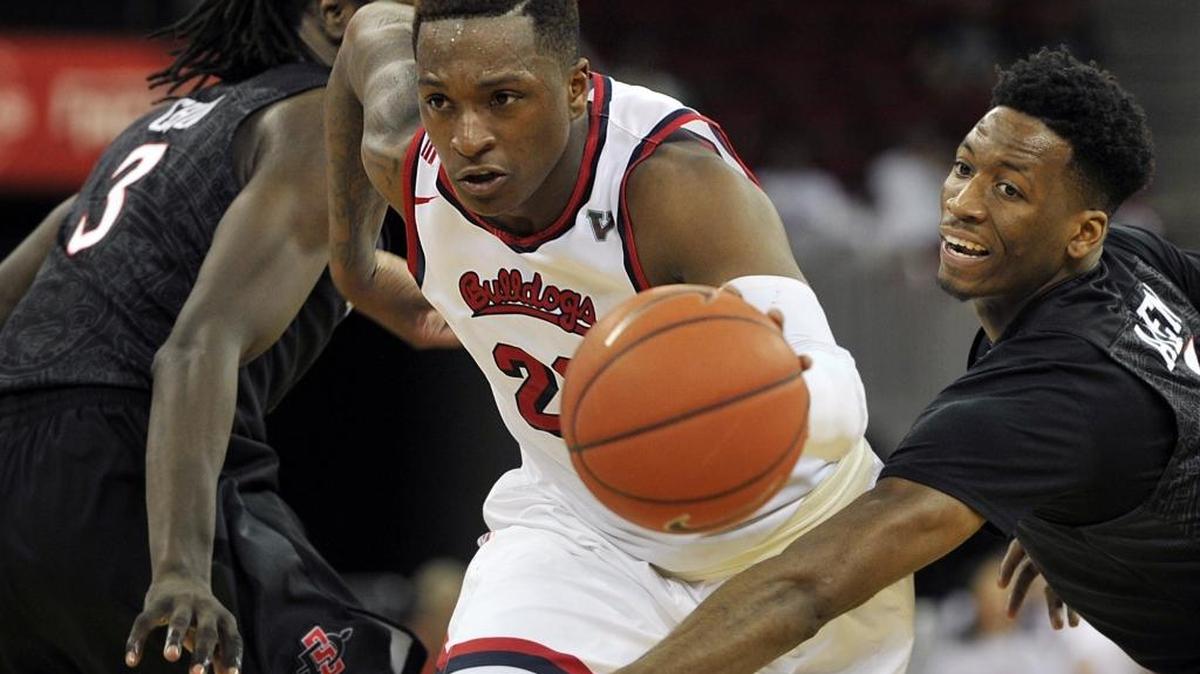 Senior guard Marvelle Harris, shown splitting the defense of San Diego State’s Angelo Chol, left, and Dakarai Allen earlier this season, is on track to separate Bulldog great Melvin Ely from Fresno State’s career scoring record.