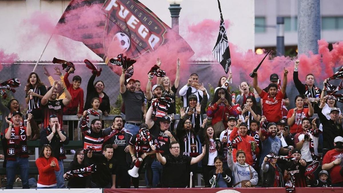 Fire Squad Fresno fans cheer the first of four Fresno Fuego goals during a 4-0 triumph over the Burlingame Dragons during the May 6 Premier Development League opener at Chukchansi Park.