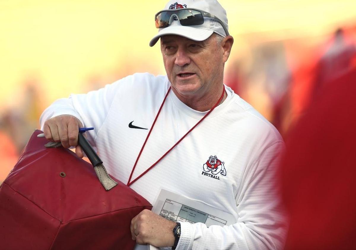 Fresno State coach Jeff Tedford gets hands on with a blocking pad during the first spring practice, Monday morning, March 12, 2018.