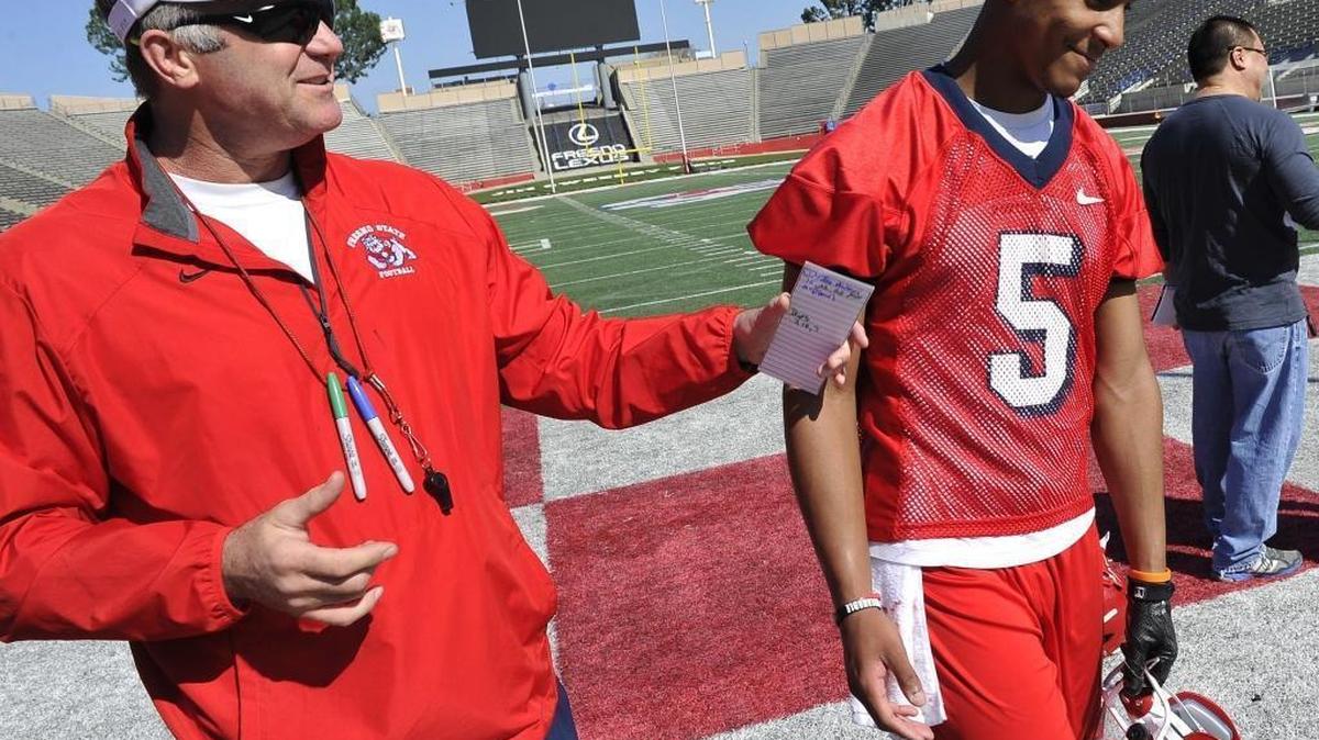 Fresno State coach Tim DeRuyter razzes quarterback Chason Virgil after practice about a pick he threw on the first day of spring ball 2016. DeRuyter believes in the “different energy” among the players and revamped staff after a 3-9 season in 2015.