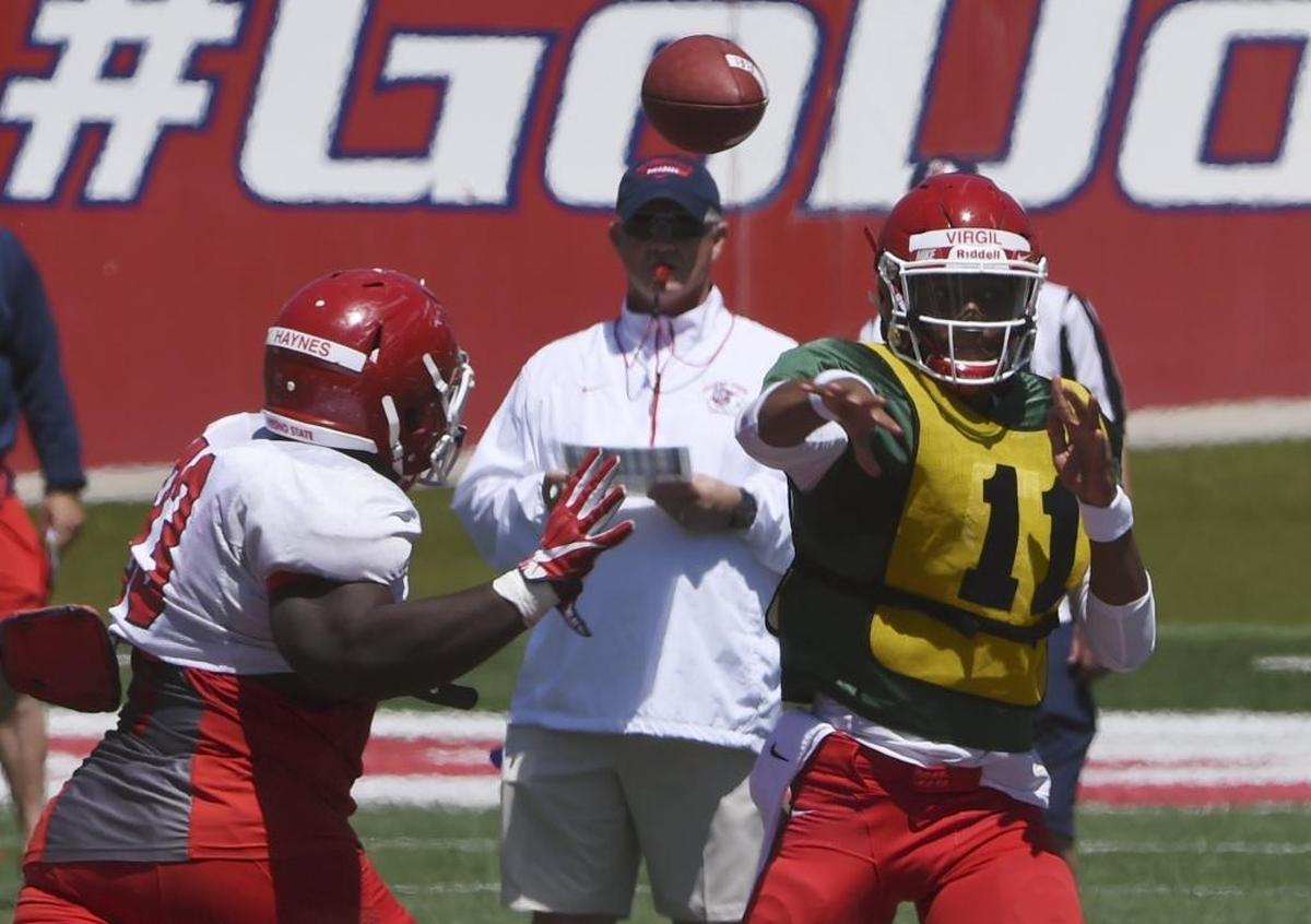 Fresno State head coach Jeff Tedford, center, keeps an eye on quarterback Chason Virgil, right, under pressure from Jasad Haynes, left, during the April 29 Spring Preview at Bulldog Stadium.