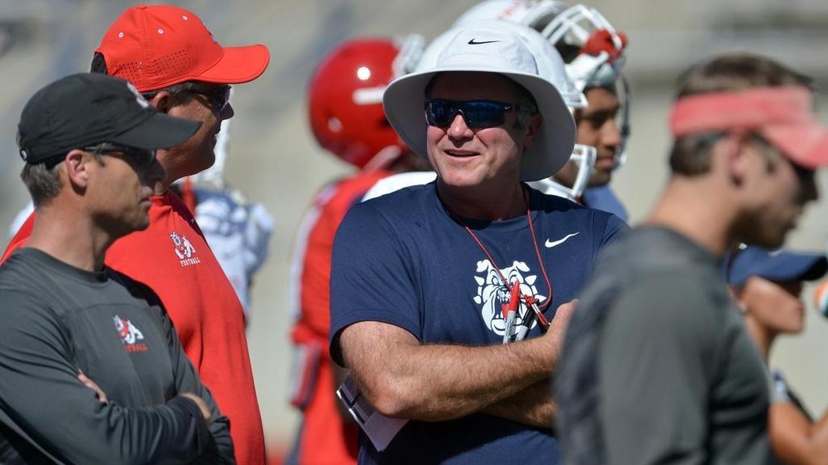 Changes are coming to the staff of Fresno State coach Tim DeRuyter, center, who has decided to dismiss offensive coordinator Dave Schramm and may replace or reassign defensive coordinator Nick Toth, left.