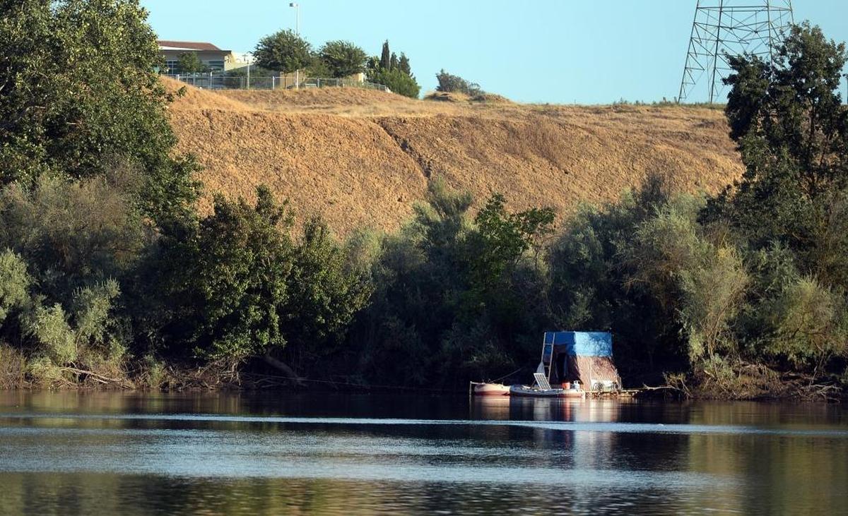 A makeshift houseboat and a couple of rafts are moored on the bank of the San Joaquin River in the River West-San Joaquin Parkway area north of Fresno on Friday, June 30, 2017.