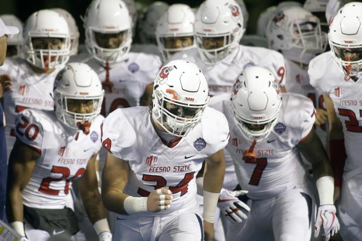 Fresno State linebacker George Helmuth (34) leads the Bulldogs onto the Albertsons Stadium field prior to Saturday night’s Mountain West championship game in Boise, Idaho.
