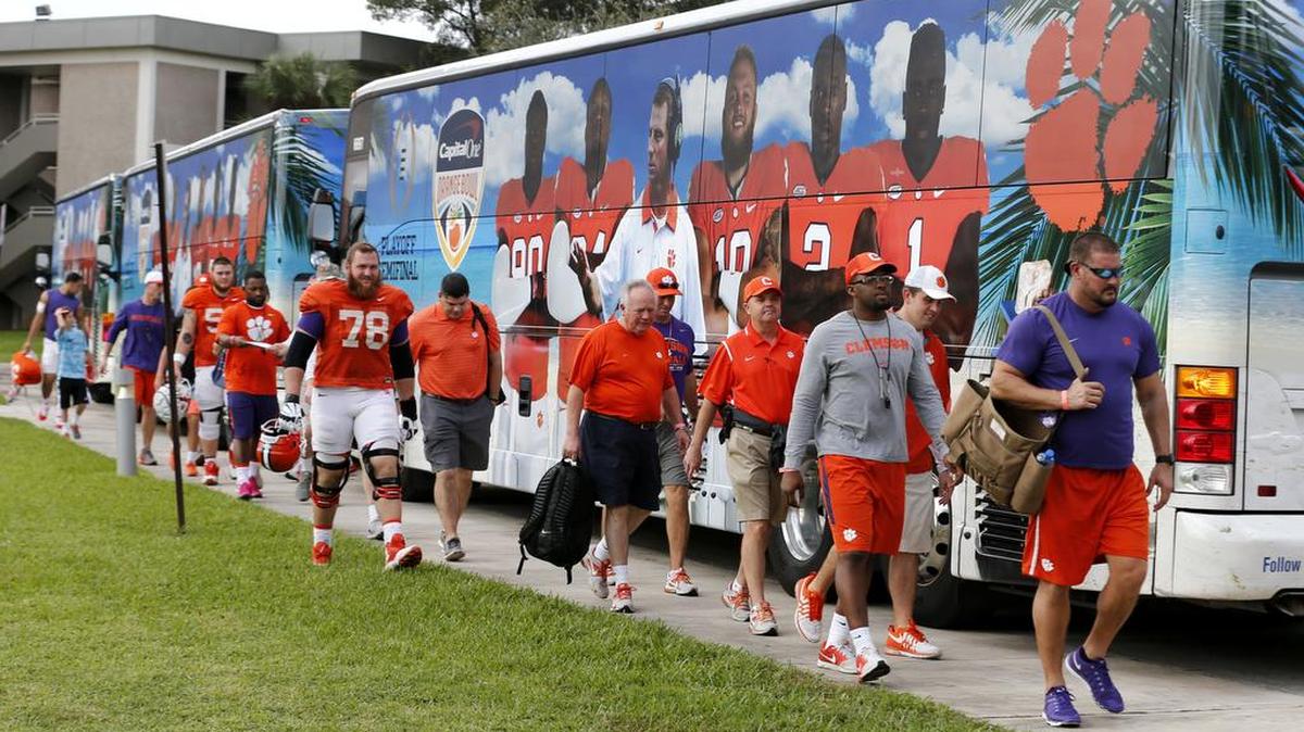 Clemson players walk from buses to practice on Monday, Dec. 28, 2015, in Davie, Fla. Clemson is scheduled to play Oklahoma in the Orange Bowl on New Year's Eve in the first College Football Playoffs semifinal. Alabama plays Michigan State in the Cotton Bowl in the second semifinal that day.