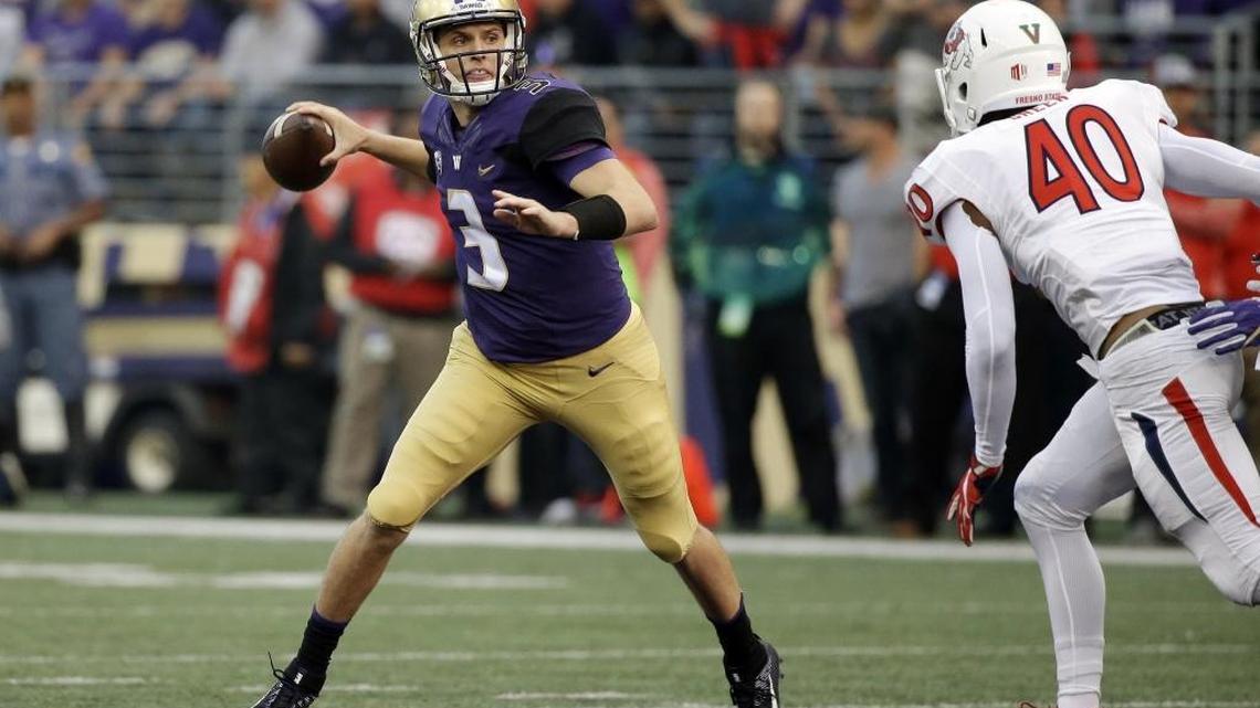 Washington quarterback Jake Browning looks to throw as Fresno State's Justin Green gives chase during the first half Saturday’s game.