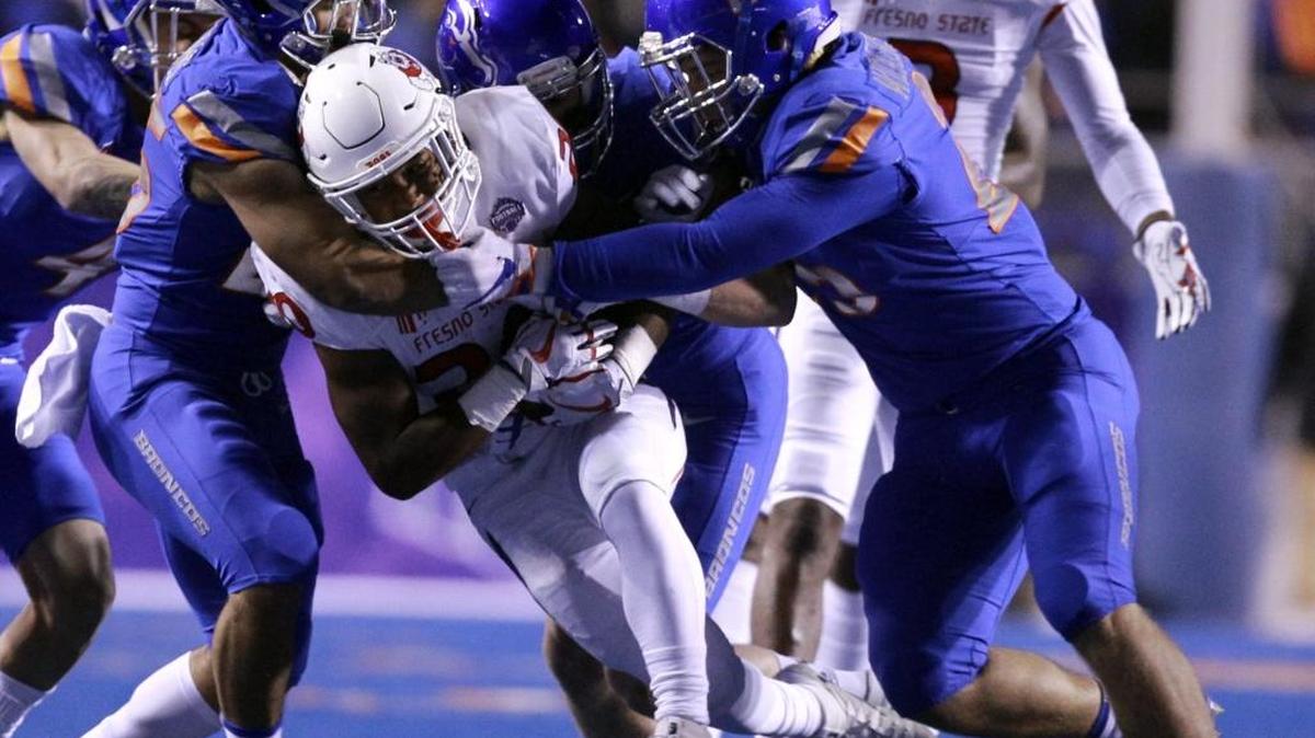 Boise State defenders bring down Fresno State running back Ronnie Rivers during the Broncos’ 17-14 victory in Saturday’s Mountain West Conference championship game at Albertsons Stadium.