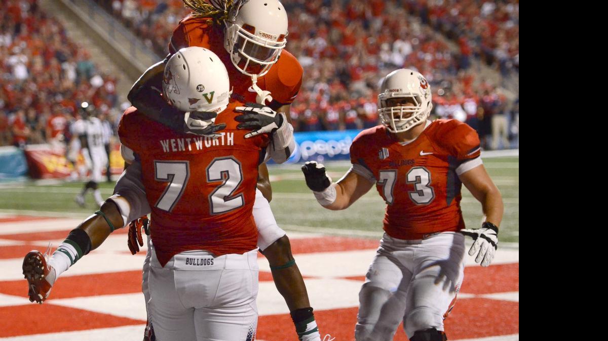 
Fresno State teammates congratulate offensive lineman Austin Wentworth after he scored a touchdown on a trick play against Cal Poly in a Sept. 7, 2013, game. Undrafted out of college, he made the roster of the Minnesota Vikings but will call it a career after just one season because of complications from blood clots in his legs.
