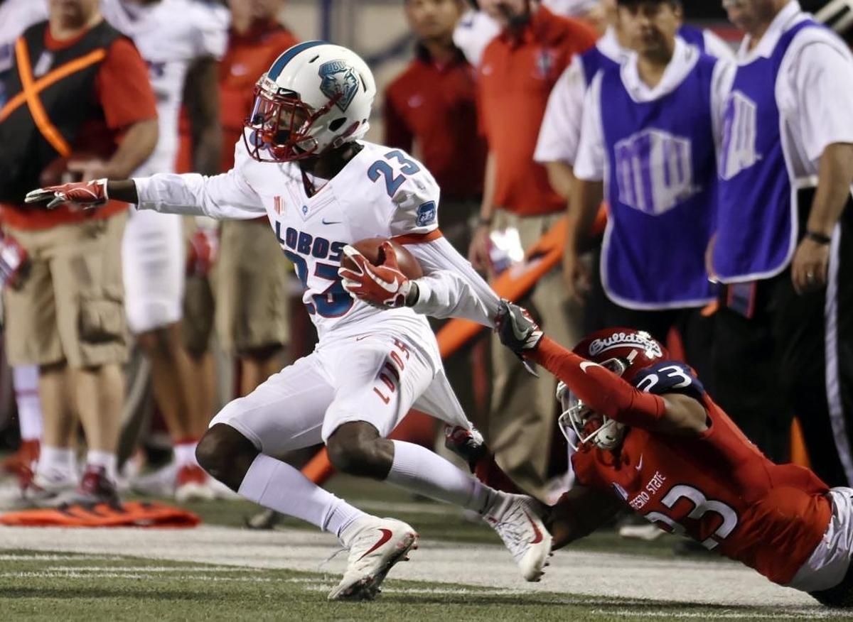 Fresno State safety Juju Hughes, right, pulls down New Mexico’s Jay Griffin IV during the first half of the Bulldogs’ 38-0 thrashing of New Mexico on Saturday night at Bulldog Stadium.